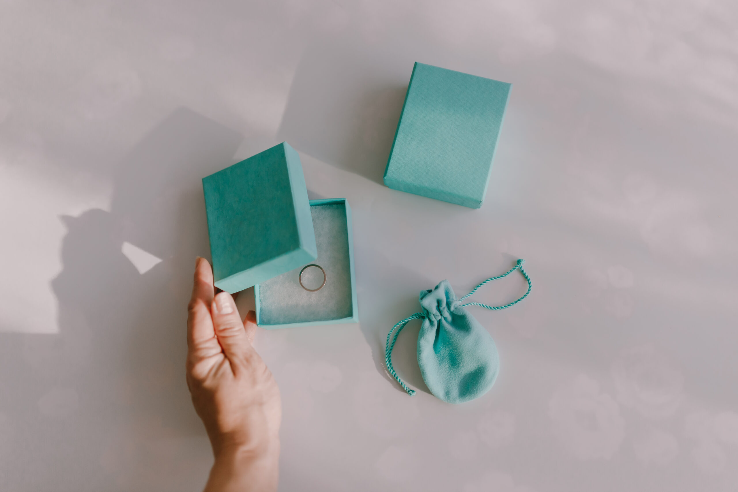 high-angle-view-hand-opening-box-with-ring