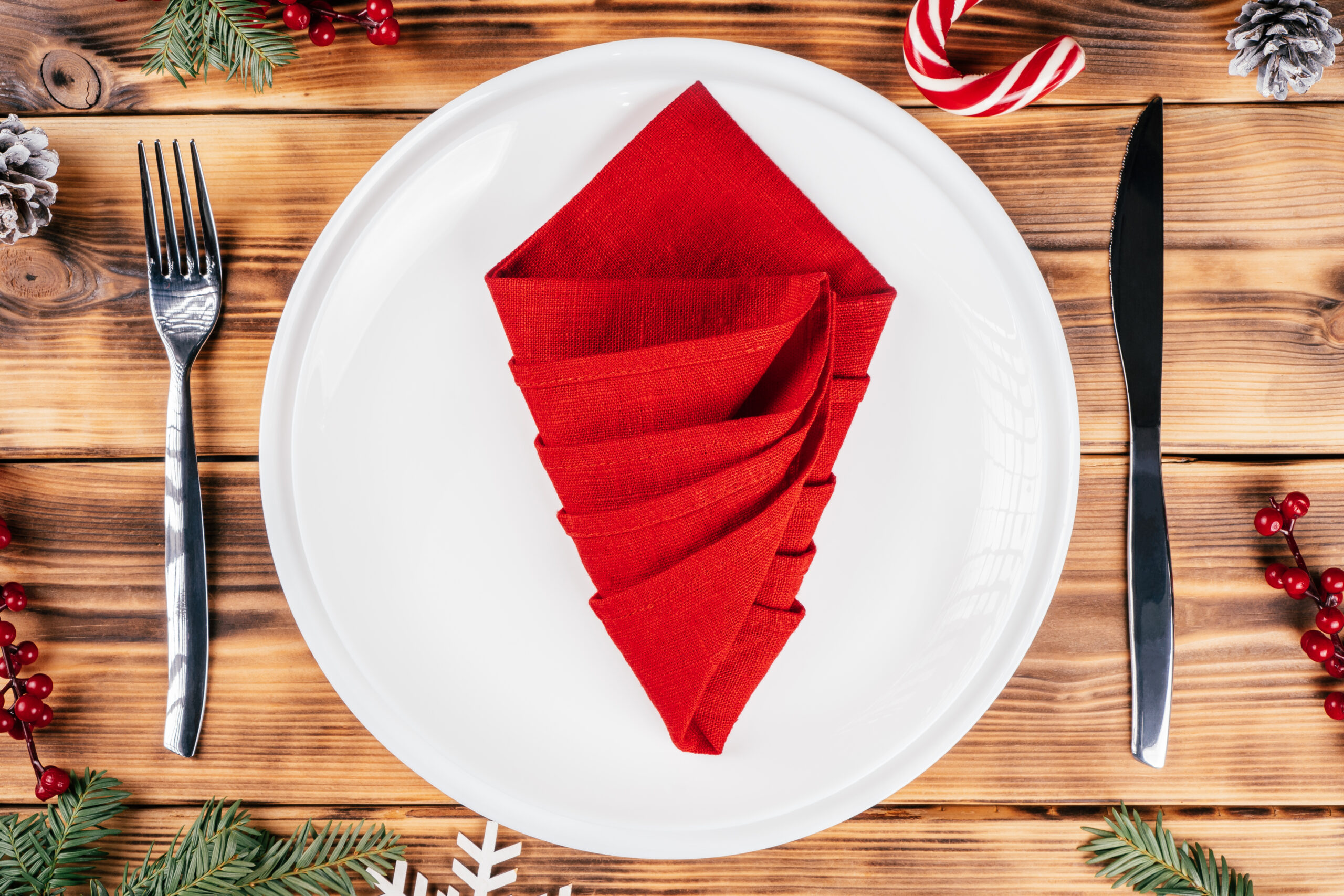 Step-by-step tutorial: Fold linen napkin in shape of Christmas tree. New Year table setting. Step 6: Fold second side to make sharp corner. Top view