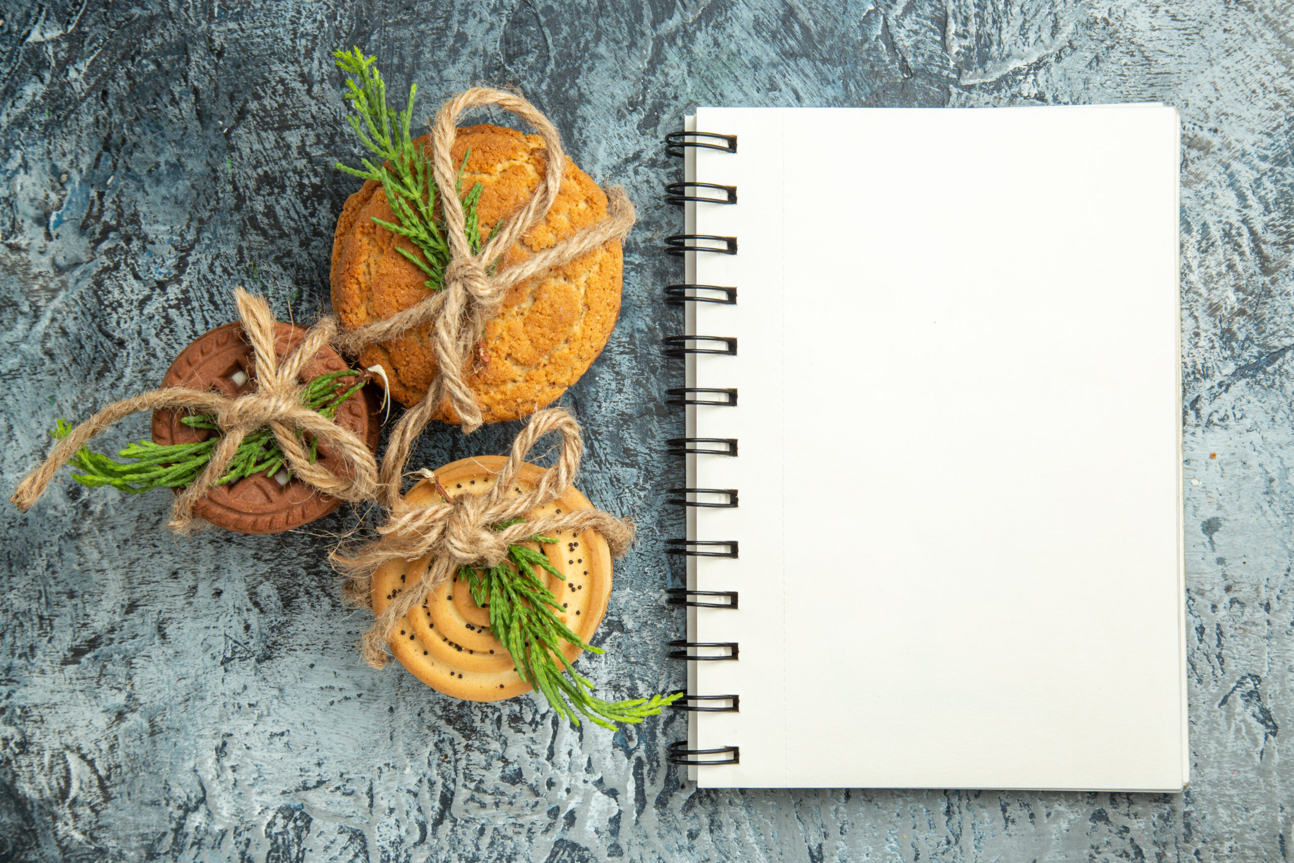 top-view-cookies-tied-with-ropes-notepad-grey-surface