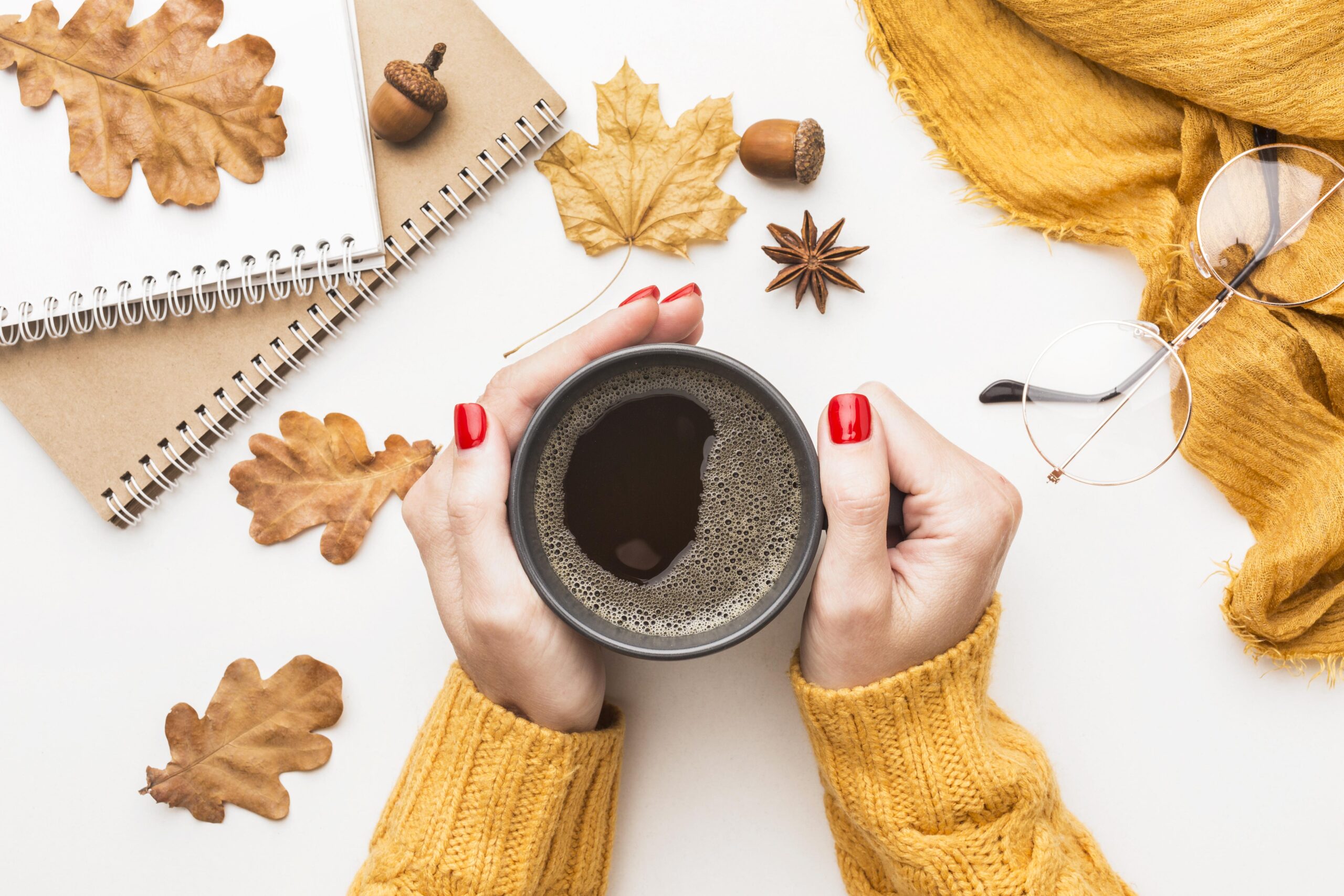 top-view-person-holding-coffee-cup-with-autumn-leaves